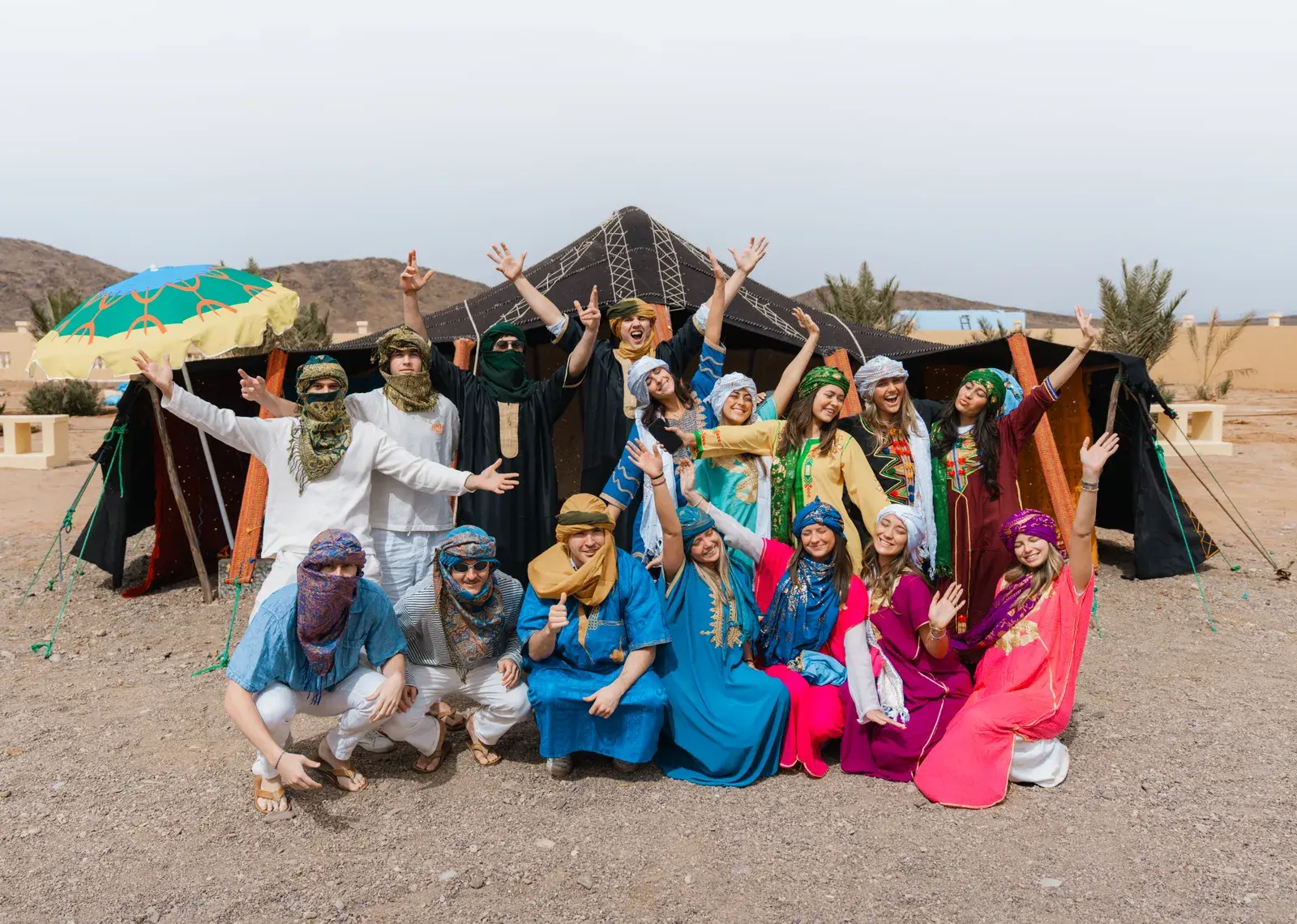 Students wearing colorful Berber dresses at the desert camp