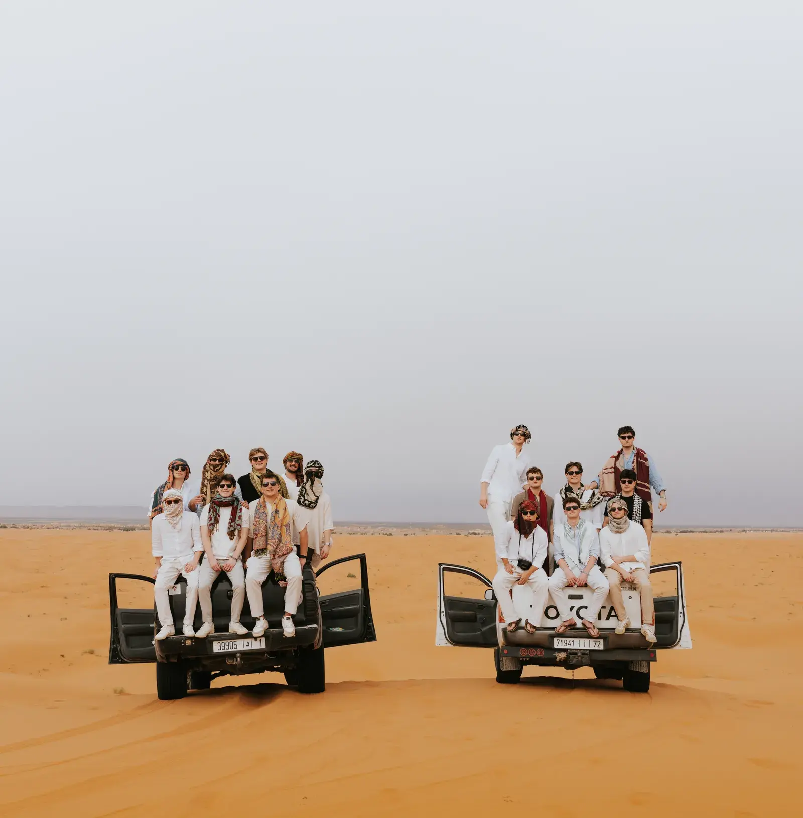 Students having fun in 4x4 pickup trucks on the Sahara dunes